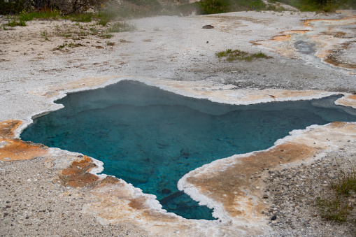 The colorful minerals and waters of the geothemal hot pools at Old Faithful in Yellowstone National Park in summer.