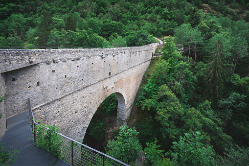 Pont d'Ael, historic Roman aqueduct bridge near Aymavilles. The bridge crosses the Grand Eyvia creek in the forest. Pondel, Aosta valley, Italy