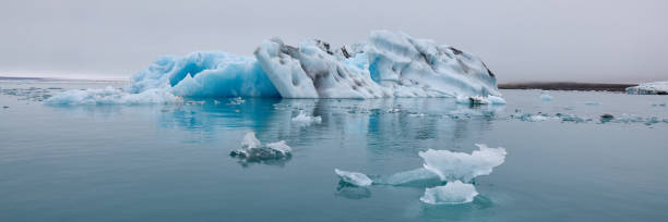 un iceberg azul en islandia. un iceberg que desemboca en la laguna de jokulsarlon, separado del frente del glaciar. - natural disaster glacier iceberg melting fotografías e imágenes de stock