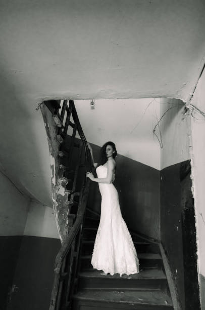 Sexy woman standing on toes in the middle of a severe damaged house.
