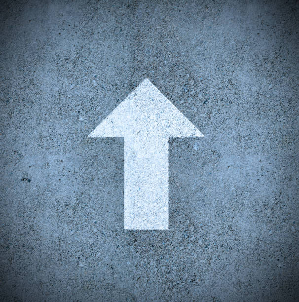 A prominent arrow symbol painted on the road surface serves as a metaphorical guide, not just pointing to the physical direction ahead for motorists, but also symbolizing forward momentum, the pursuit of success, the essence of progress, and the anticipation of a promising future.
