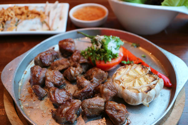 istock Delicious diced beef steak on sizzling hot plate with blurry side dishes in the backdrop 1624861930