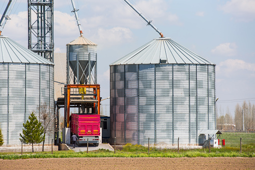 Tanker truck refilling some large silos for food industry