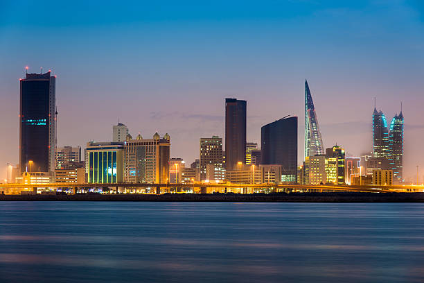 Bahrain Manama by Night Illuminated skyline of Manama with office buildings, hotels and the world trade center of bahrain at twilight. Manama, Bahrain, Middle East. manama stock pictures, royalty-free photos & images