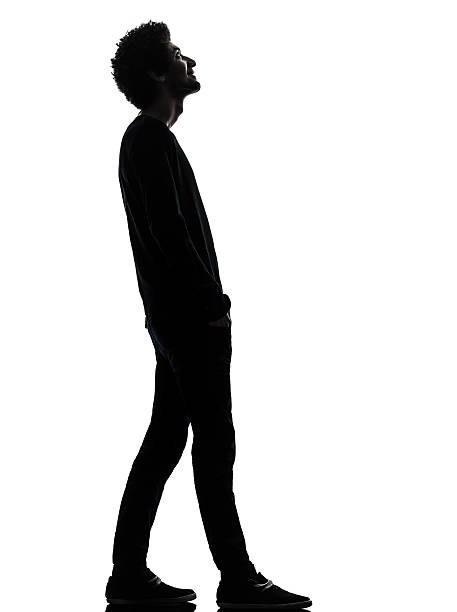 istock handsome african young man standing looking up smiling silhouette 162493402