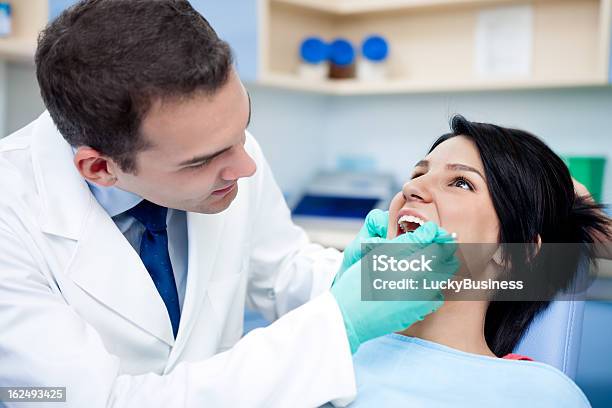 Dentista Trabajando En Paciente De Dientes Foto de stock y más banco de imágenes de Adulto - Adulto, Asistencia sanitaria y medicina, Azul