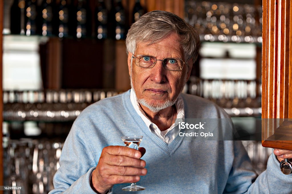Starszy człowiek w barze picie szklanki Genever - Zbiór zdjęć royalty-free (Bar - Lokal gastronomiczny)