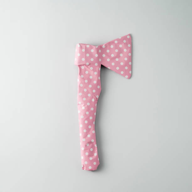 istock Rough axe packaged in pink polka dot gift paper on a blue background. Top view. 1624944057