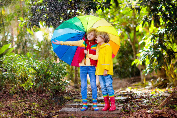 istock Child playing in autumn rain. Kid with umbrella. 1624949995
