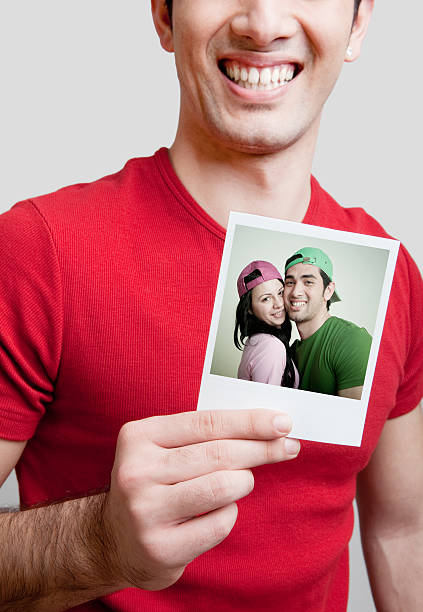 junger mann hält foto - polaroid transfer fotos stock-fotos und bilder