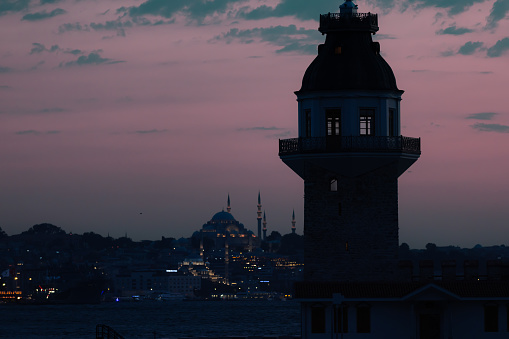 Silhouette of Istanbul cityscape with Maiden's tower at sunset.