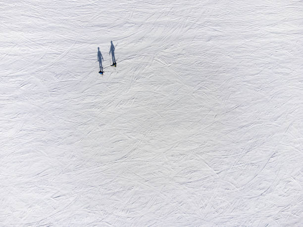 istock directly above two skiers on snow on ski slope in various shadow positions 1625011891