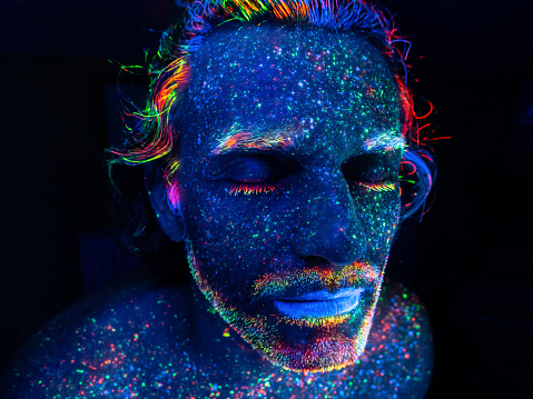 Male portrait painted with fluorescent colours under UV lights