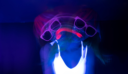 Light painting portrait of a young woman with eyeglasses. New art direction, long exposure photo without processing, light drawing at long exposure