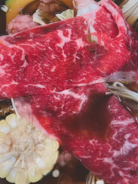 Photo of Raw thin beef slices in hot boiled with many vegetable