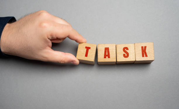 istock Task word concept. Business tasks and goal setting. Strategy and business management. Businessman holding wooden blocks 1625087069