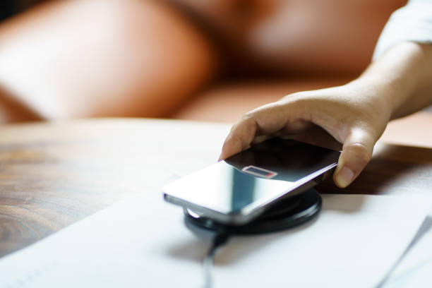 istock Charging mobile phone battery with wireless charging device in the table. Smartphone charging on a charging pad. Mobile phone near wireless charger Modern lifestyle technology concept 1625088320