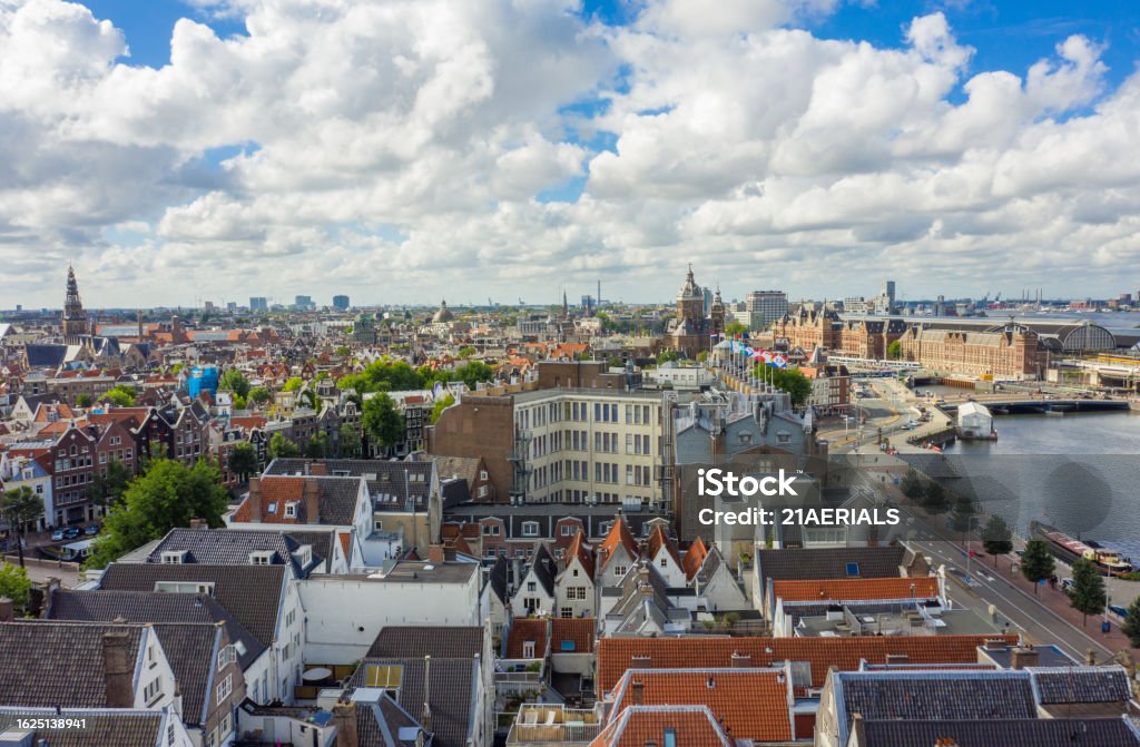 Beautiful View over Amsterdam Rooftops and Cityscape from Aerial perspective next to Oosterdok with Blue Sky and big clouds Beautiful View over Amsterdam Rooftops and Cityscape from Aerial perspective next to Oosterdok with Blue Sky and big clouds HQ Above Stock Photo