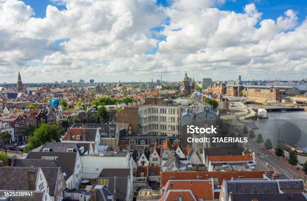 Beautiful View Over Amsterdam Rooftops And Cityscape From Aerial Perspective Next To Oosterdok With Blue Sky And Big Clouds Stock Photo - Download Image Now