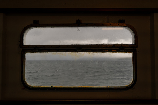 Seeing through the porthole on a ferry, Scotland, overcast weather, see through, transparent, stormy