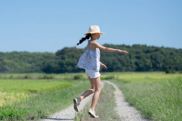 istock Child playing on the rice field road 1625192604