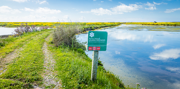 Sign of the natural reserve of Lilleau des Niges near a basin of the ornithological park on the Ile de Ré, France