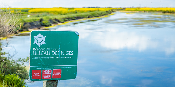 Sign of the natural reserve of Lilleau des Niges near a basin of the ornithological park on the Ile de Ré, France