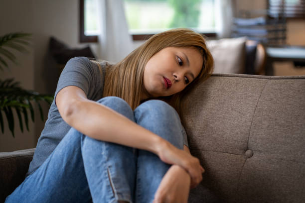 istock Stressed, anxious and depressed woman sitting on sofa at home alone 1625221531