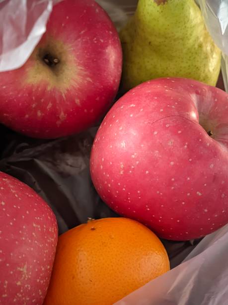 istock Apples, oranges and green pears in clear white plastic 1625221543