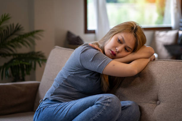 istock Stressed, anxious and depressed woman sitting on sofa at home alone 1625221552