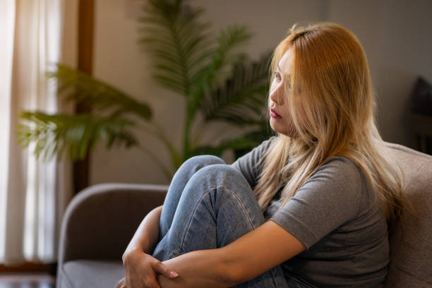 istock Stressed, anxious and depressed woman sitting on sofa at home alone 1625221554