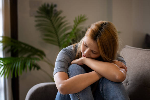 istock Stressed, anxious and depressed woman sitting on sofa at home alone 1625221559
