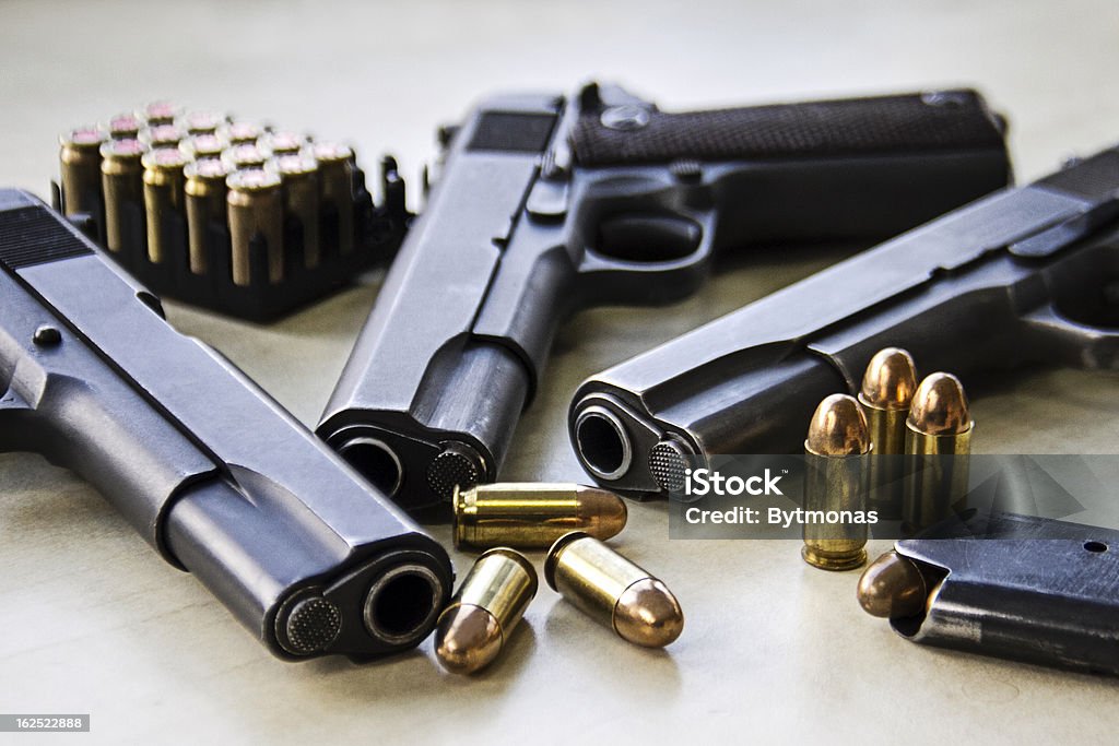 Three pistols Three pistols laying on table with bullets Gun Stock Photo