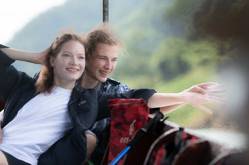 A young couple sits on a boat for a journey into the forest above the dam for trekking.