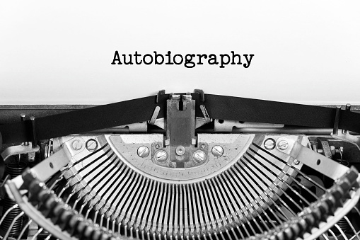 Autobiography word closeup being typing and centered on a sheet of paper on old vintage typewriter mechanical.