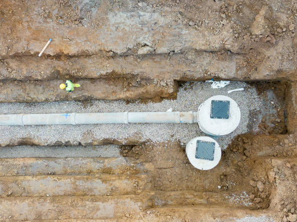 Aerial view of a construction worker inspecting a drainage trench