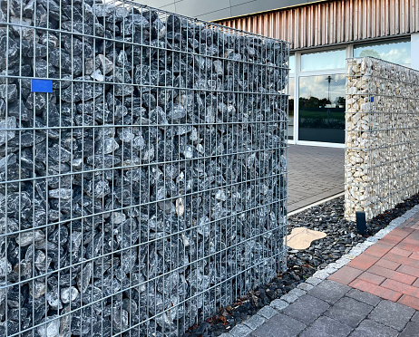 Fence made of stones in a grid (gabion) for the house.