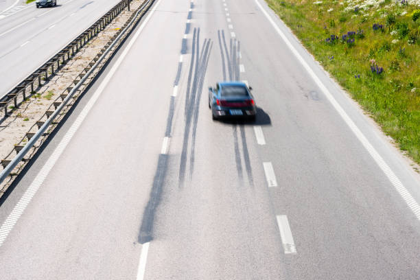 Red car drives on asphalt forest road.\nRoad trip on countryside. Welder - Germany.