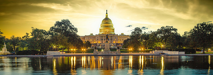 Panoramic image of the Capitol of the United States with the capitol reflecting pool in morning light.