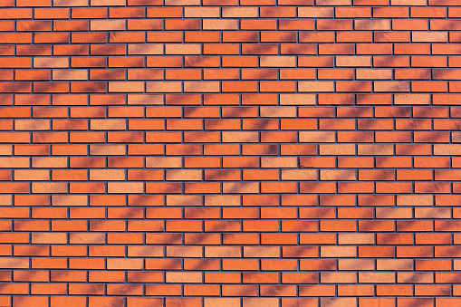 A new, neat, clean wall made of red ceramic, clinker brick. Background image, texture