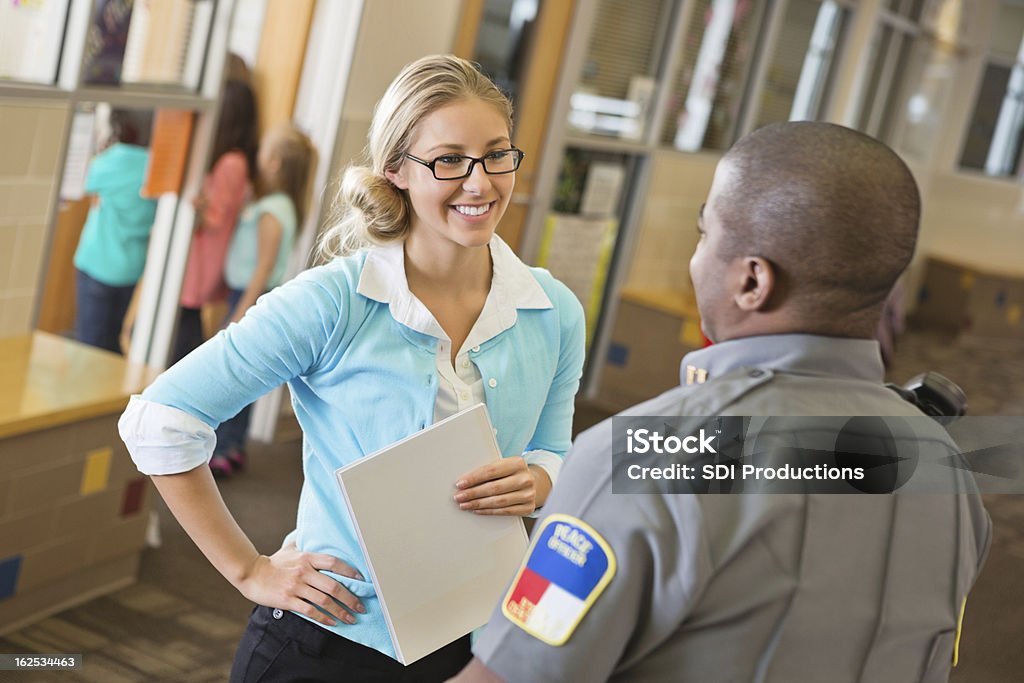 Elementary school teacher talking with police officer after safety demonstration Police Force Stock Photo