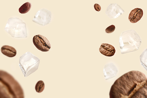 Coffee concepts. Iced coffee backgrounds. Flying coffee beans and ice cubes on the colored background with copy space