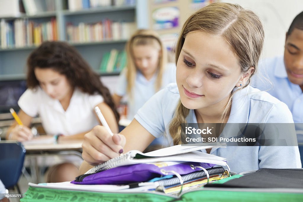 Jovem estudante escrever completo de alunos em sala de aula - Foto de stock de Adolescente royalty-free
