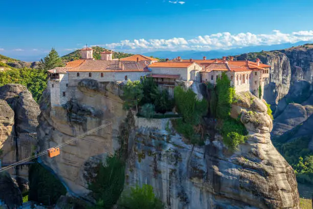Greece, Meteora monasteries. Panoramic view on the Holy Monastery of Varlaam placed on the edge of high rock. The Meteora area is on UNESCO World Heritage. Greece, Europe