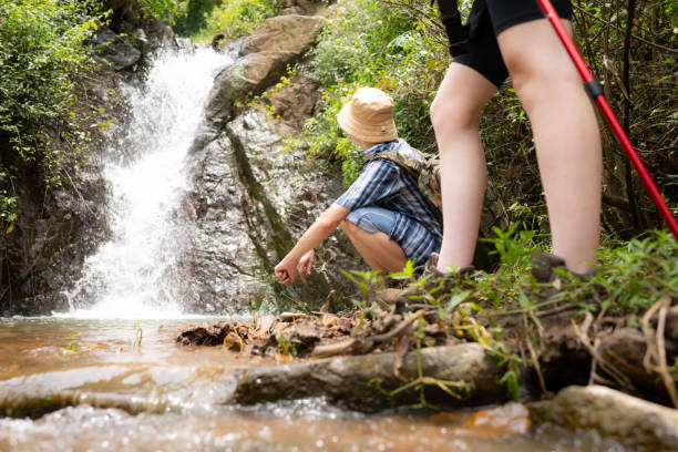 istock Young couple hiker with a backpack standing in front of a waterfall 1625408828