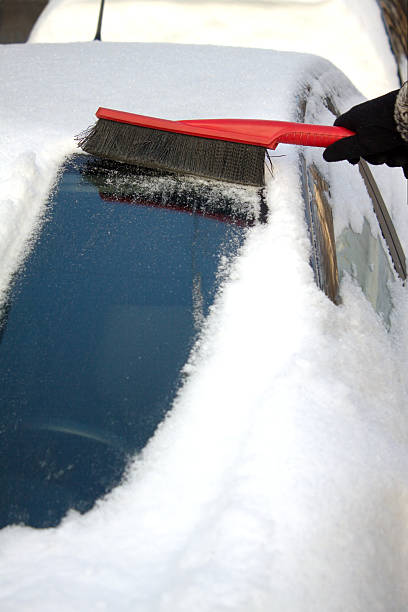 istock Woman brushing snow from a car 162542998