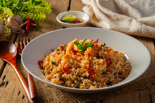 Spicy Shrimp and minced pork Fried Rice with thai holy basil leaves in white plate.