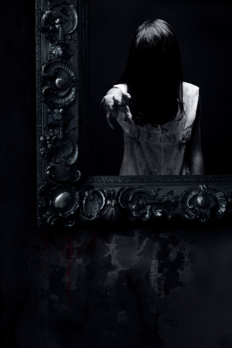 Old mirror with scary reflection. Halloween theme.
