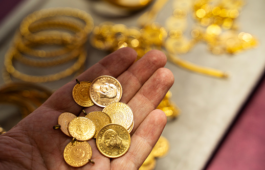 Human hand holding Turkish Gold coin in hand