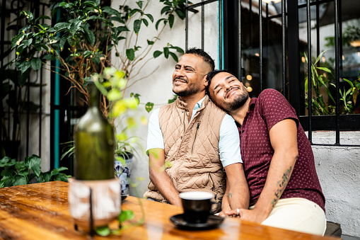 Gay couple embracing at a coffee shop